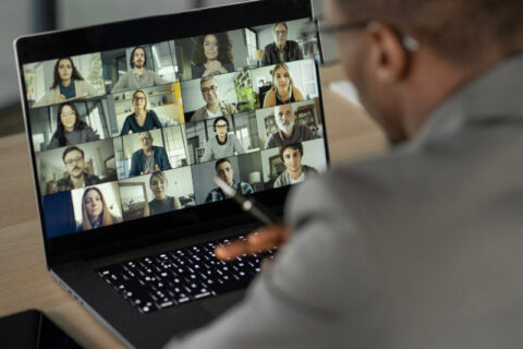 Man attending meeting on laptop