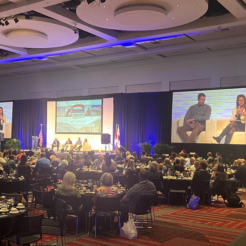 Large conference with a stage and Projector screens using AV services for an event in Denver, CO