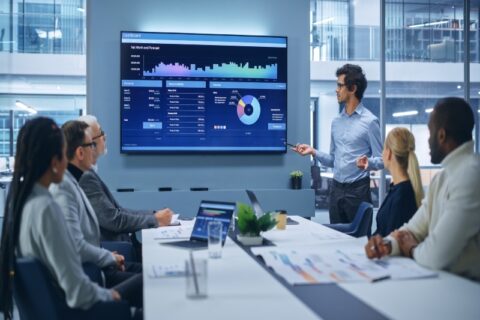 A meeting featuring a dashboard presentation showing AV trends in a conference room in Denver, CO