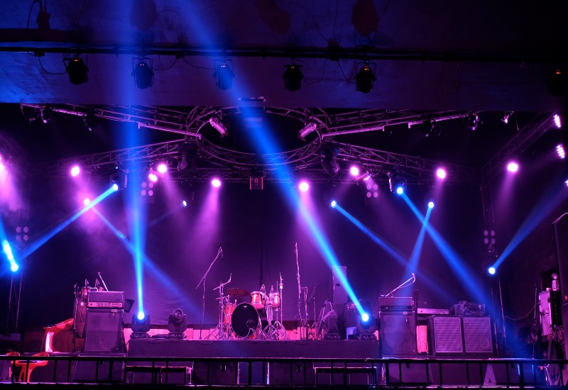 A concert stage with purple & blue lights, showcasing event production trends in Denver, CO