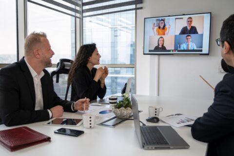 A team in hybrid meeting room with remote participants in a conference room in Denver, CO