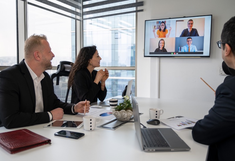 A team in hybrid meeting room with remote participants in a conference room in Denver, CO